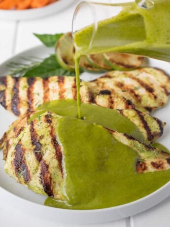 Perfectly grilled chicken with vibrant green herb sauce