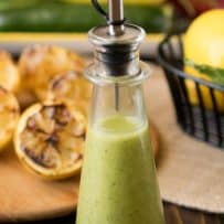 Grilled lemon and basil vinaigrette that is a pretty shade of green in a glass bottle