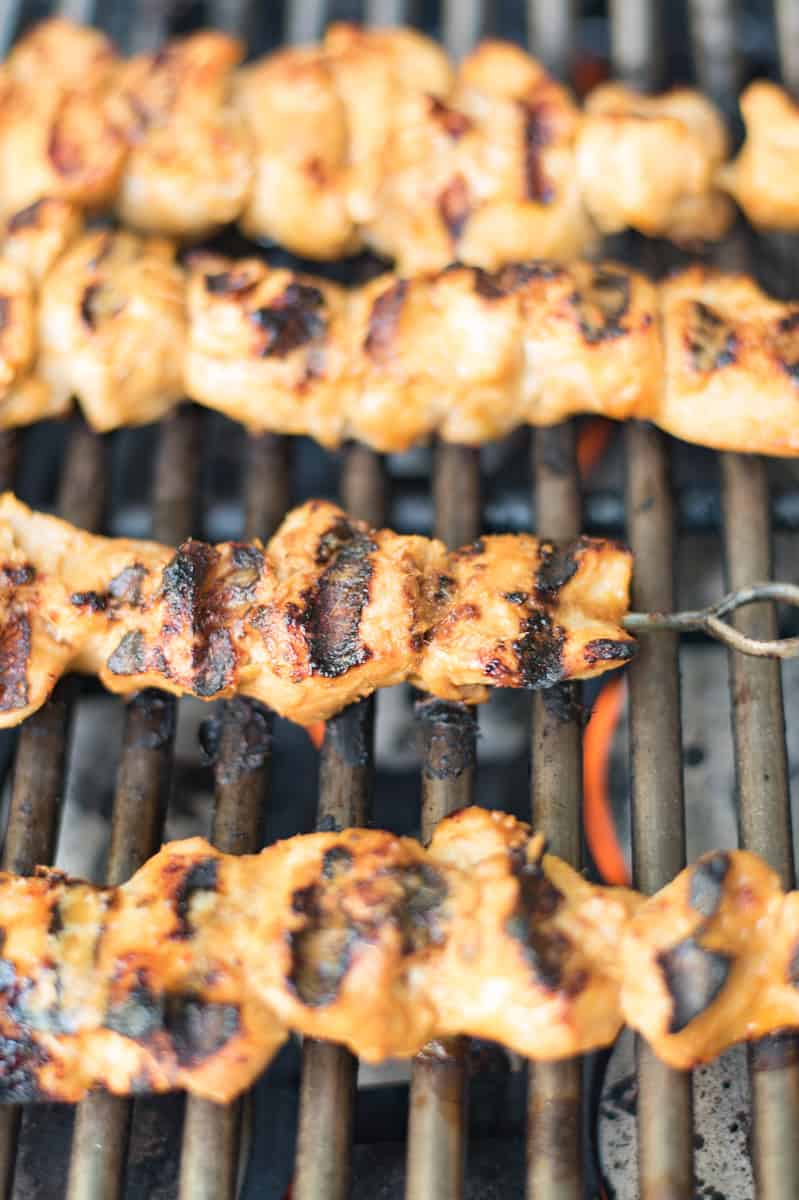 Chicken on skewers being grilled on a barbecue