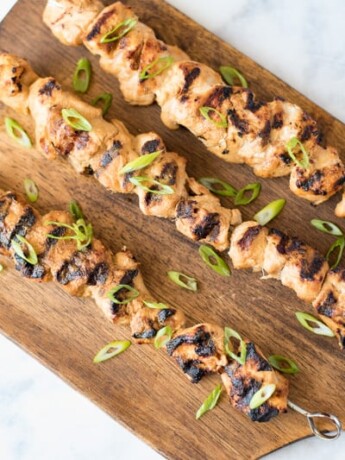 An overhead image of 3 skewers on a board