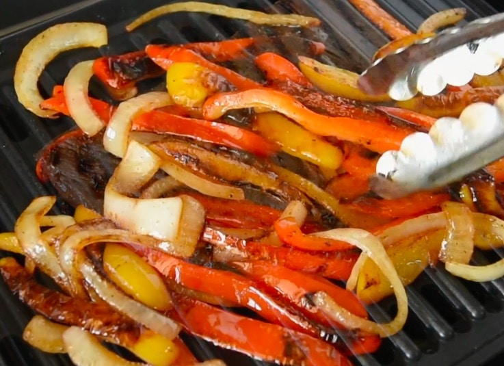 Onions and peppers getting the perfect char on the grill