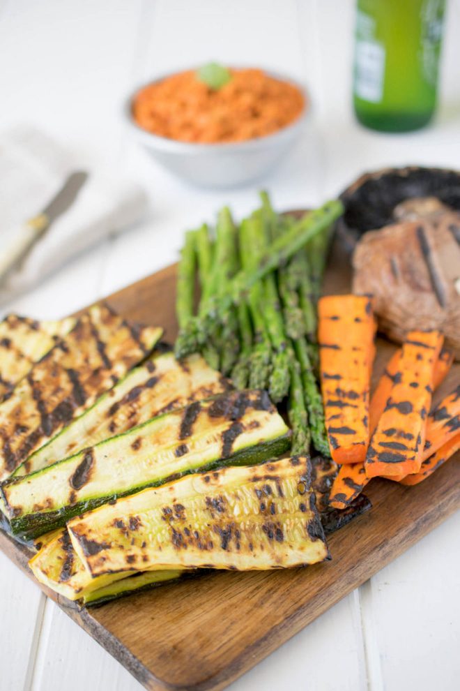 Grilled zucchini, carrots, asparagus and mushrooms on a serving board with sun-dried tomato dip