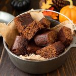 Squares of parkin cake are piled in a grey dish