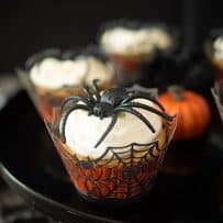 A closeup showing the spiderweb cupcake liner, creamy frosting and large spider decoration