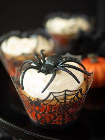 A closeup showing the spiderweb cupcake liner, creamy frosting and large spider decoration