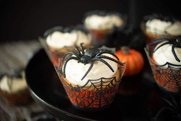 A closeup showing the spiderweb cupcake liner, creamy frosting and large spider decoration