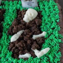 A graveyard made from brownie with a white chocolate skeleton and green frosting grass