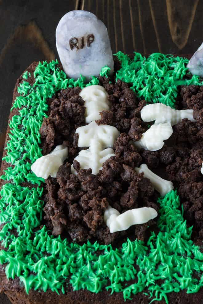 A Halloween brownie graveyard made from brownie, green frosting grass and a cookie headstone