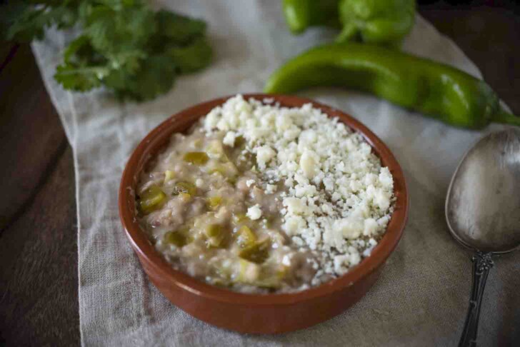 A bowl of refried beans topped with queso cheese