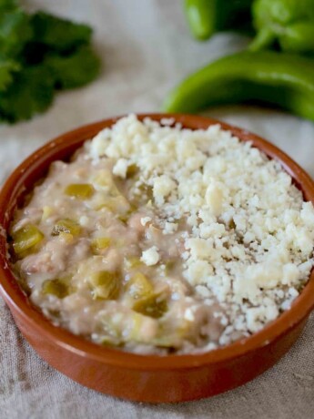 Refried beans mixed with hatch Chile peppers topped with crumbled cheese