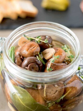 A closeup of brown mushrooms, herbs and garlic
