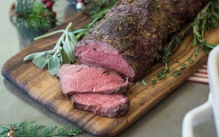 A sliced beef tenderloin coated with herbs