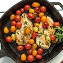 Herbed Brown Butter Chicken with Tomatoes in a cast iron skillet garnished with fresh rosemary