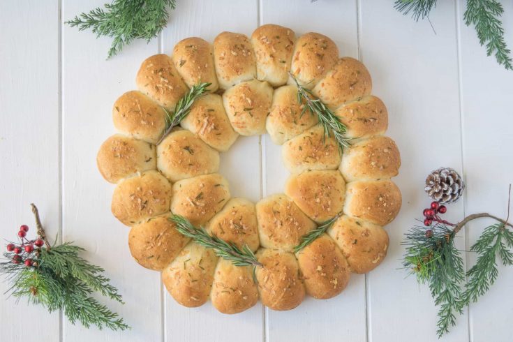 Holiday rosemary bread wreath is a stunning holiday recipe that can be used as an edible centerpiece. Soft bread rolls flavored with fresh rosemary and parmesan.