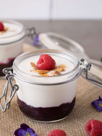A glass jar filled with yogurt and fruit