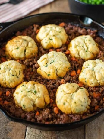 A pan of minced beef and carrots topped with crispy dumplings