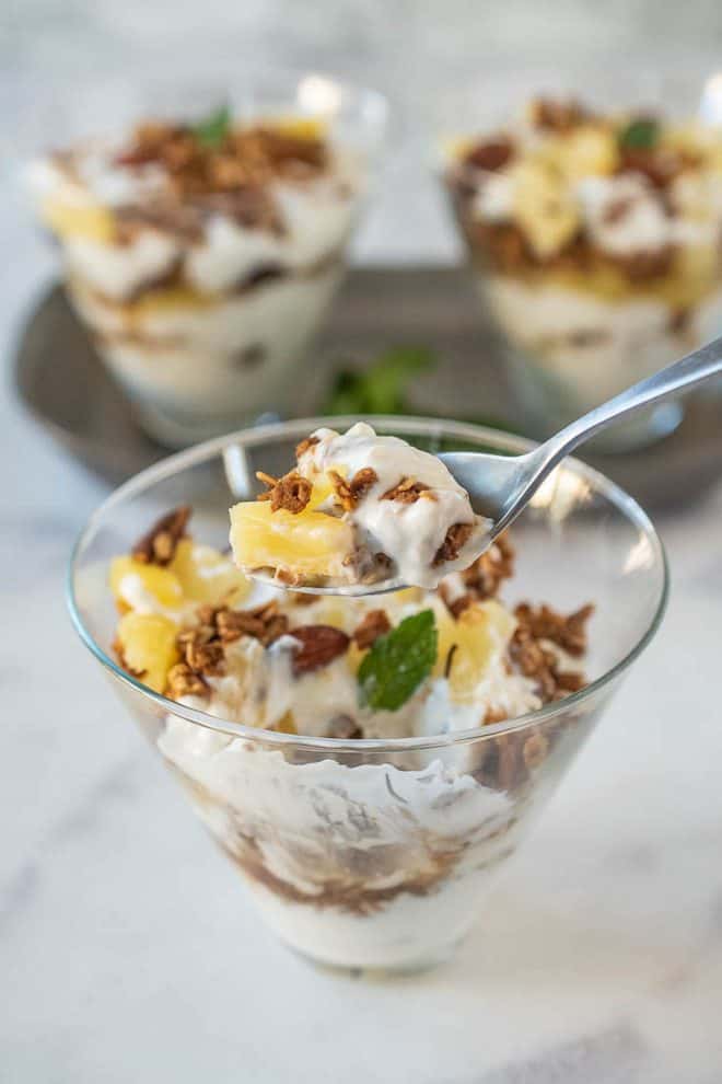 A spoonful of yogurt with pineapple and granola