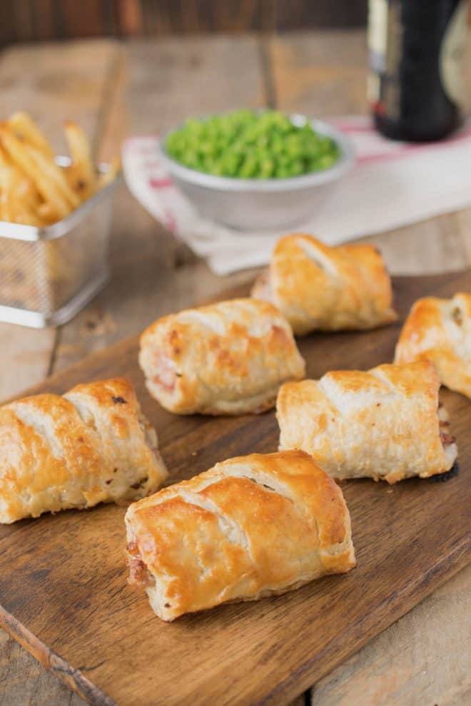 A selection of homemade sausage rolls on a serving board