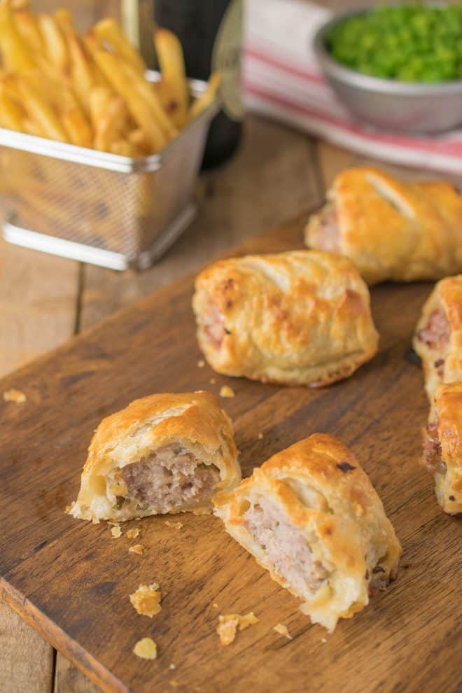 A sausage roll cut open showing the sausage filling and flaky pastry