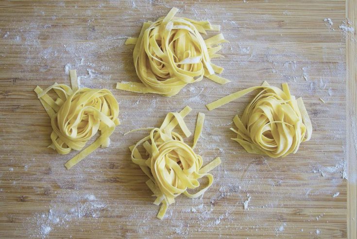 Freshly cut homemade tagliatelle pasta on a board
