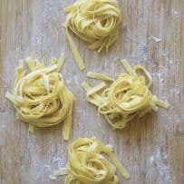 Homemade tagliatelle pasta on a board freshly made