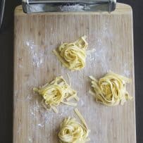 A pasta machine and homemade tagliatelle pasta