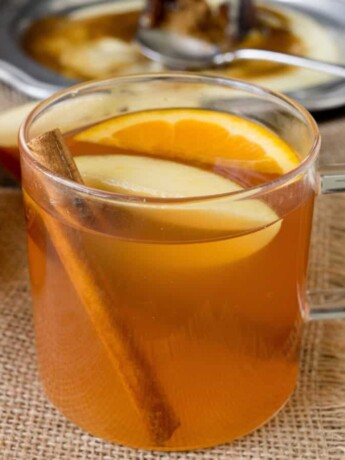 A clear mug of hot apple cider