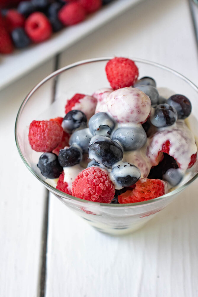 A closeup of berries in a bowl with creamy custard