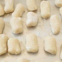 Uncooked gnocchi drying on a board