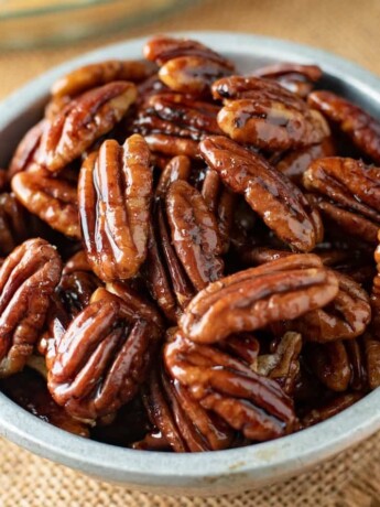 A closeup of pecan halves glazed with maple syrup