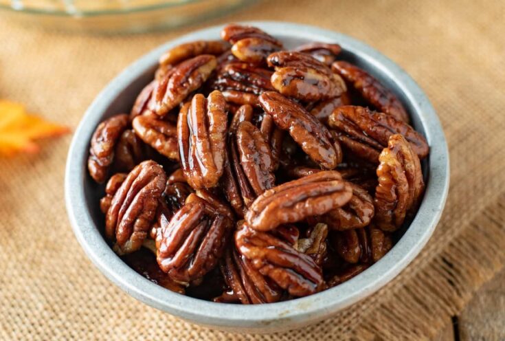 A closeup of pecan halves glazed with maple syrup