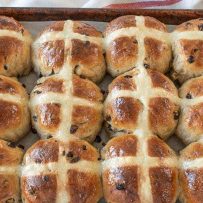 12 hot cross buns on a baking sheet fresh out of the oven