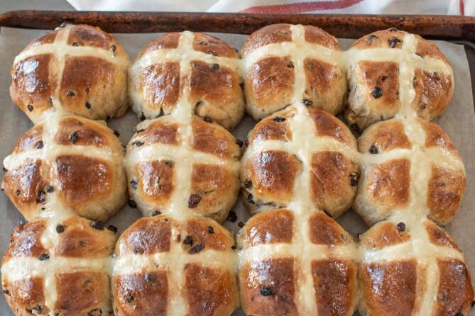 Rows of hot cross buns on a baking sheet