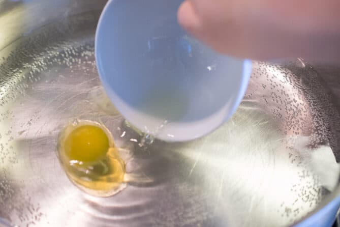 Pouring an egg into water too cook