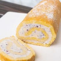 Ice cream swiss roll with a slice cut on a white plate