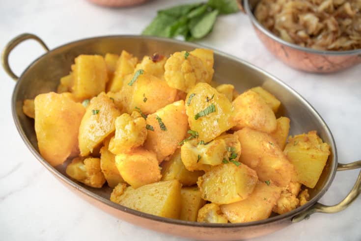 Potatoes and cauliflower seasoned with spices garnished with fresh mint
