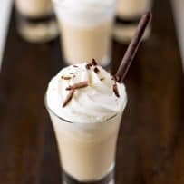 Irish coffee milkshake in a shot glass topped with whipped cream and chocolate shavings