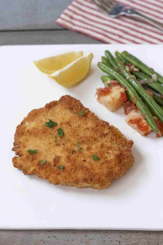 Chicken cutlets served on a plate with green beans