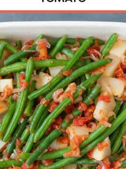 A casserole dish of Italian green beans, tomato and potatoes