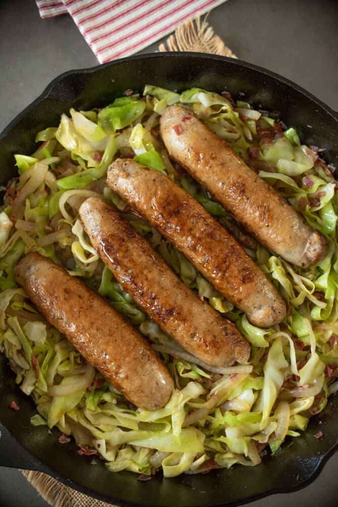 Sausages and cooked cabbage in a pan from overhead