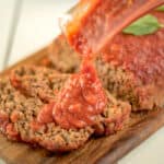 Slices of meatloaf topped with tomato marinara sauce