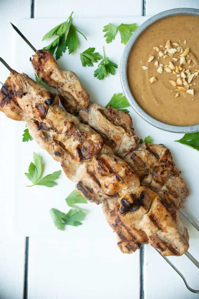 Skewers of grilled chicken with a side of peanut dipping sauce