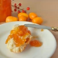 Kumquat marmalade spread onto bread on a plate