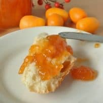 A crusty piece of bread topped with kumquat marmalade