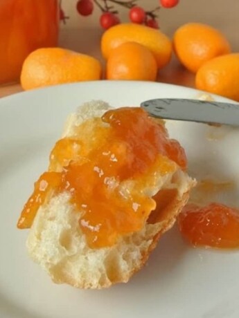 A crusty piece of bread topped with kumquat marmalade