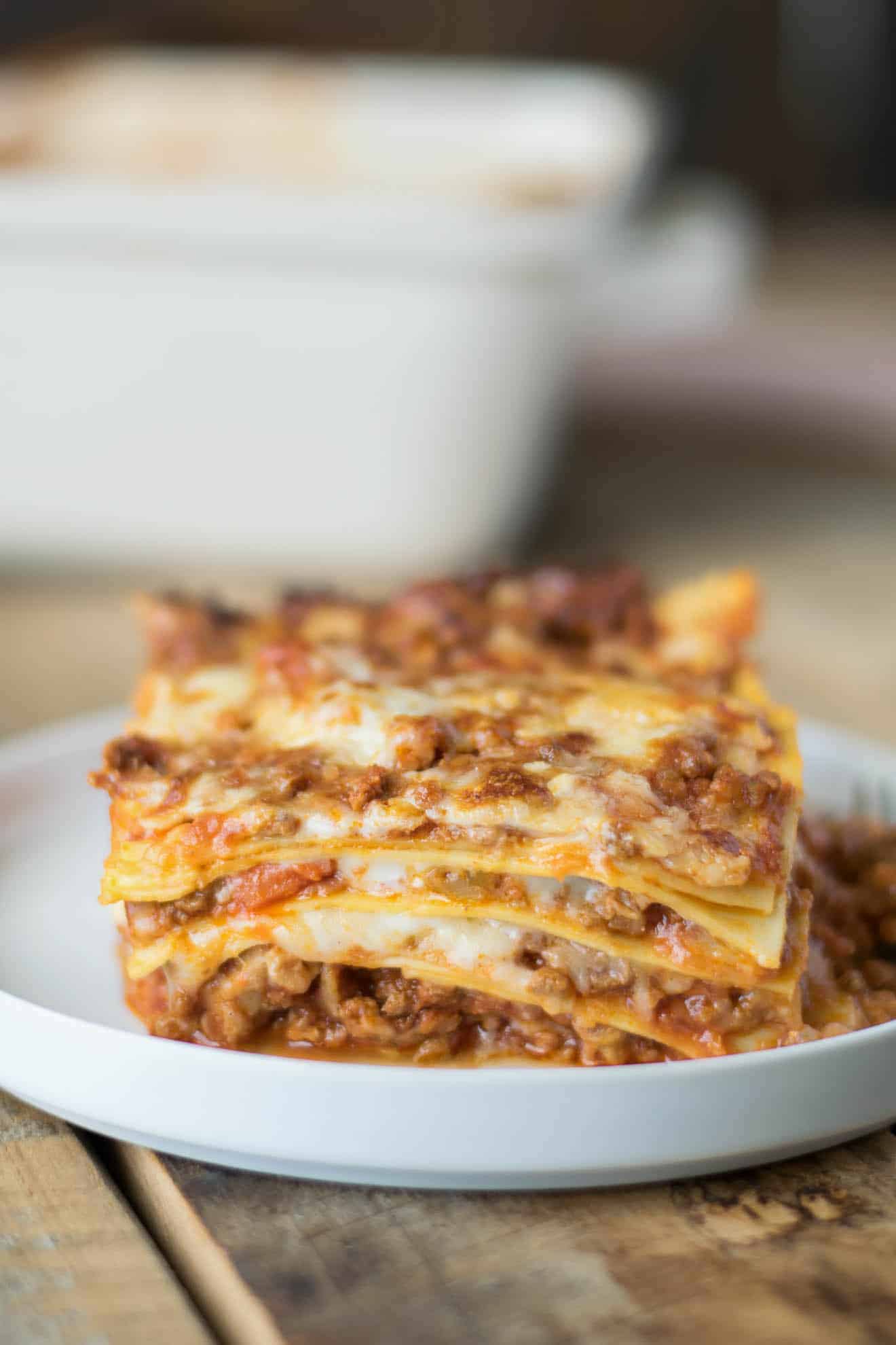A closeup of a slice of lasagna showing the layers of pasta, meat sauce and cheese.