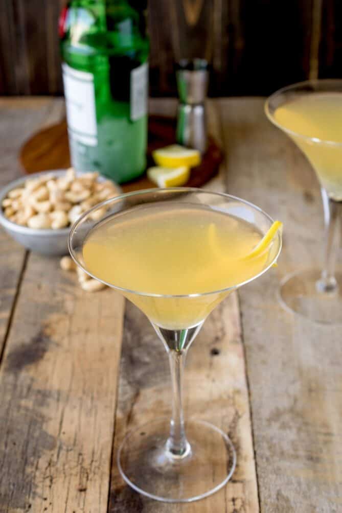 A martini glass filled with a lemony drink