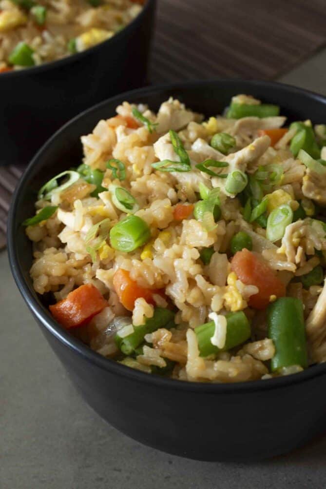 A closeup of colorful green and orange vegetables in fried rice