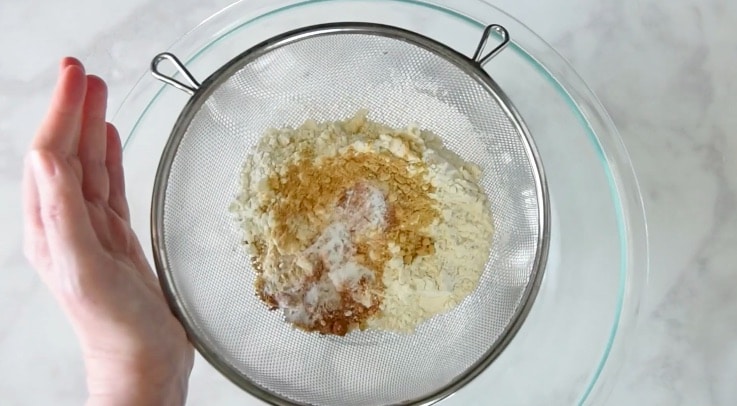 flour and ground ginger, cinnamon, nutmeg and baking soda are sifted into a glass bowl