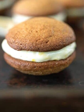 A side image of a cookie where you can see the flecks of lemon zest in the cream cheese filling